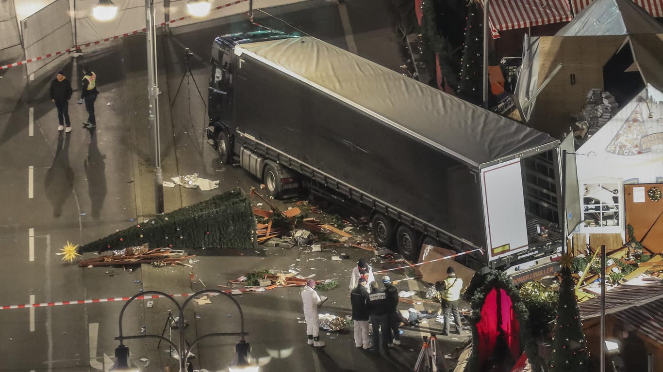 Das Tatfahrzeug: Der gestohlene polnische Lastwagen, mit dem Amri auf den Weihnachtsmarkt raste, steht neben zerstörten Buden.