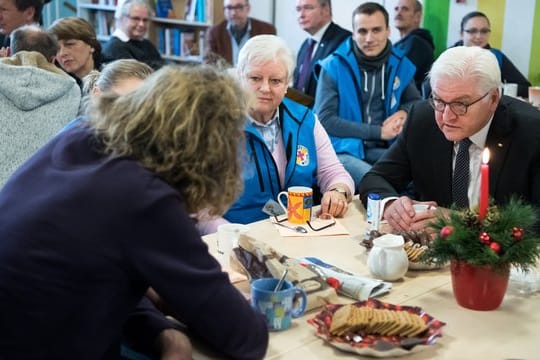 Frank-Walter Steinmeier (r) unterhält sich mit Mitarbeitern und Obdachlosen.