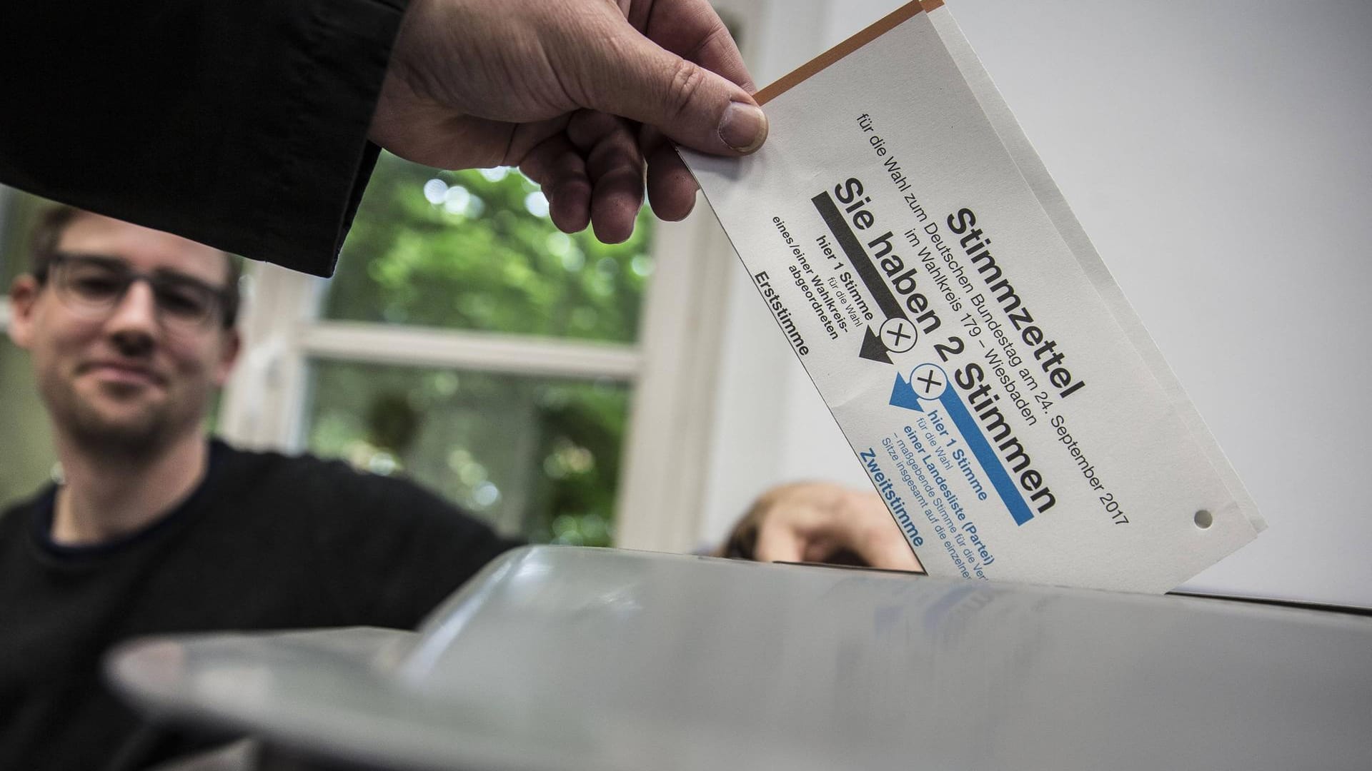 Ein Stimmzettel wird in die Wahlurne gesteckt.