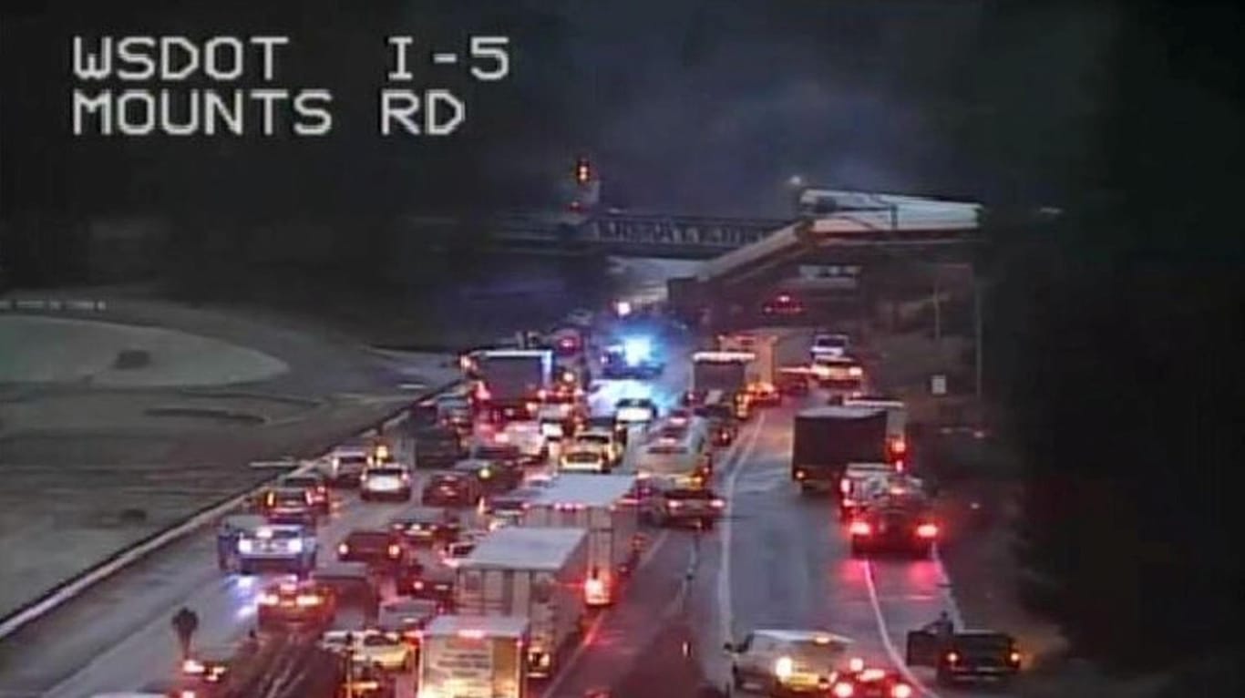 Eine Überwachungskamera zeigt Waggons des Zuges, die auf den Highway gestürzt sind.