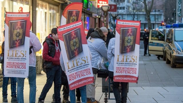 Mit einem Plakat auf dem Rücken versucht ein Teilnehmer der Koran-Verteilaktion "Lies!" Anfang 2015 die Aufmerksamkeit auf sich zu ziehen. Mit einem Plakat auf dem Rücken versucht ein Teilnehmer der Koran-Verteilaktion "Lies!" Anfang 2015 die Aufmerksamkeit auf sich zu ziehen.