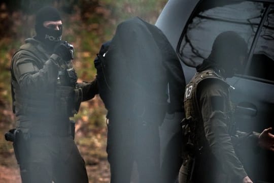 Der Verdächtige wird auf dem Gelände des Bundesgerichtshofs in Karlsruhe von Polizisten aus einem Fahrzeug geführt.