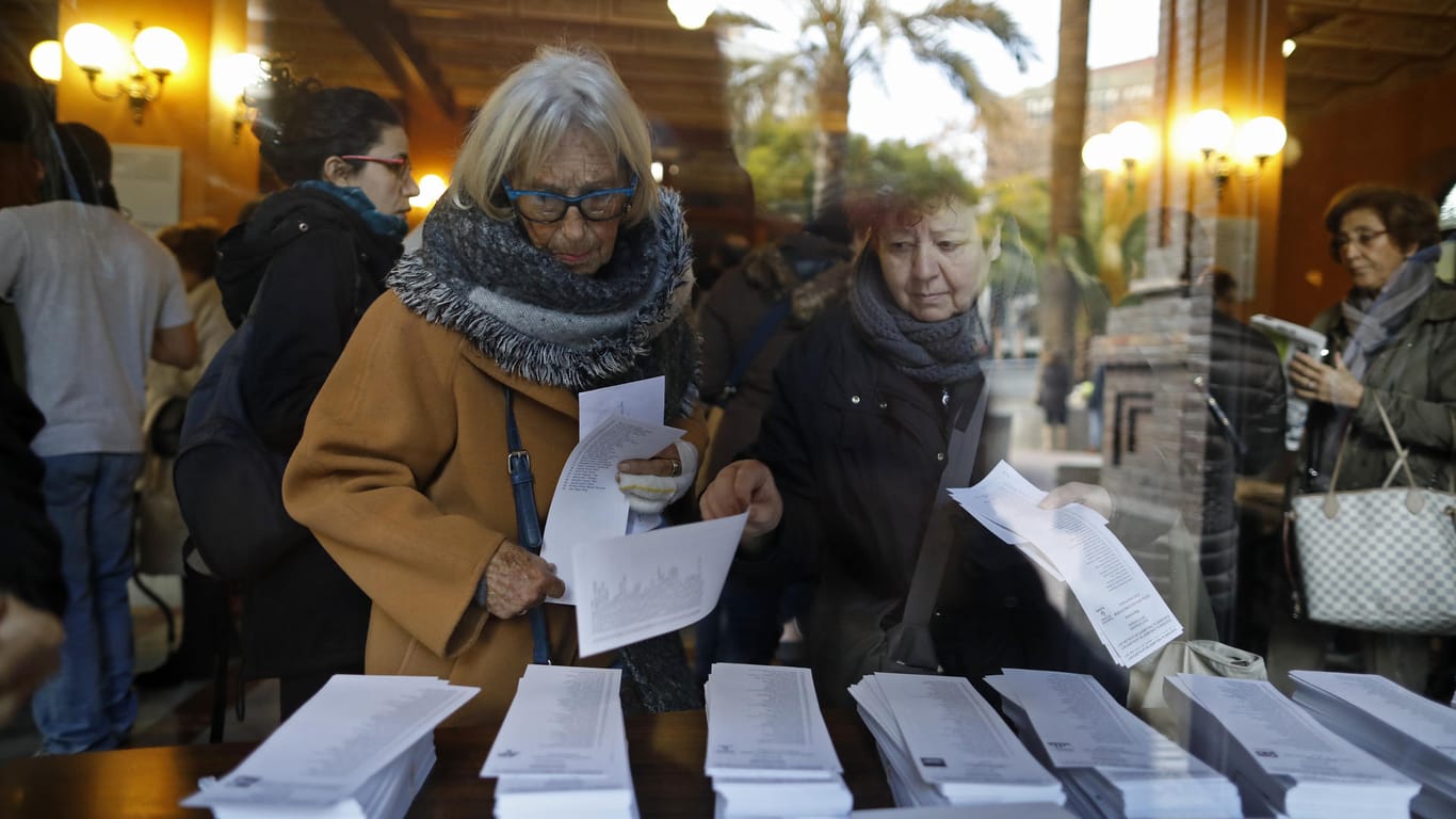 Wähler nehmen sich in Barcelona in einem Wahllokal einen Stimmzettel für die Neuwahl des Regionalparlaments in Katalonien.