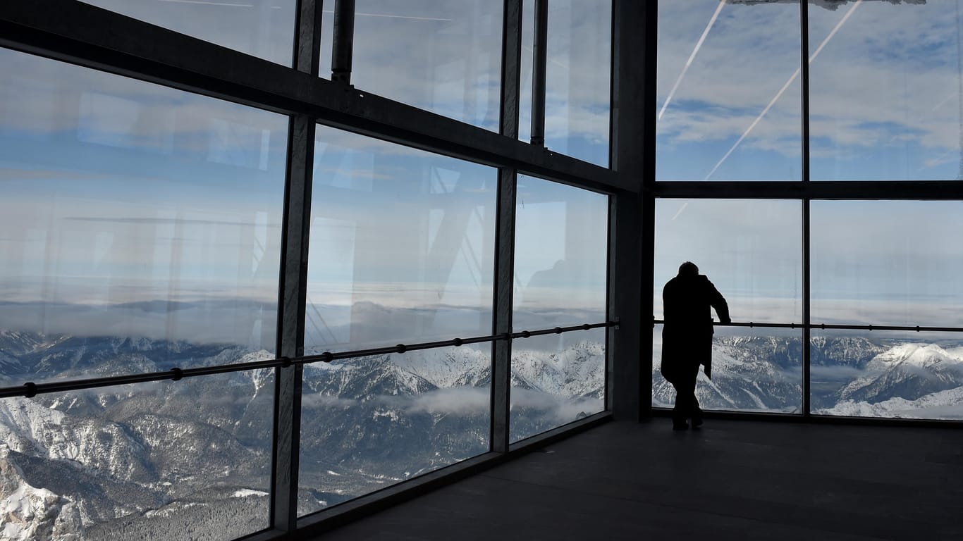 Ein Gast betrachtet in Garmisch-Partenkirchen (Bayern) in der neuen Bergstation der Zugspitzbahn das grandiose Panorama.