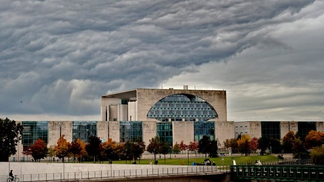 Dunkle Wolken ziehen über das Kanzleramt in Berlin.