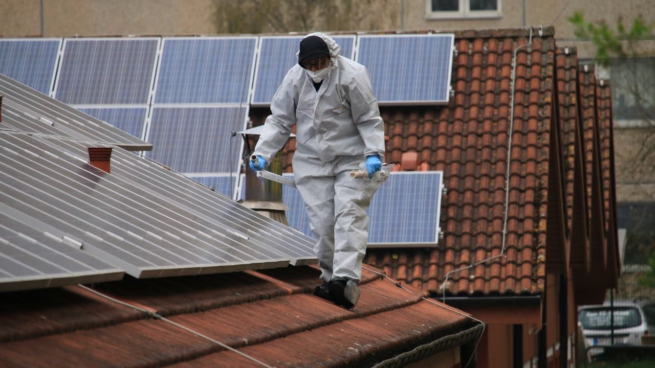 Ein Mitarbeiter der Spurensicherung auf dem Dach der Flüchtlingsunterkunft in Artern (Thüringen): Unbekannte hatten einen Brandanschlag verübt. Mehrere Brandsätze trafen das Dach des Gebäudes.