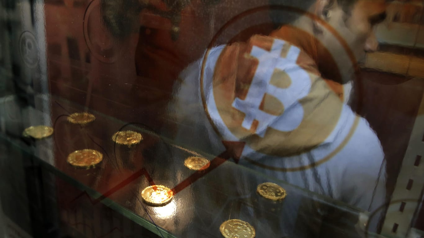 Ein Mann benutzt einen Bitcoin-Automaten. Die Digitalwährung wird nicht von zentralen Instanzen wie Notenbanken oder Regierungen kontrolliert und gewährt bei Überweisungen Anonymität.