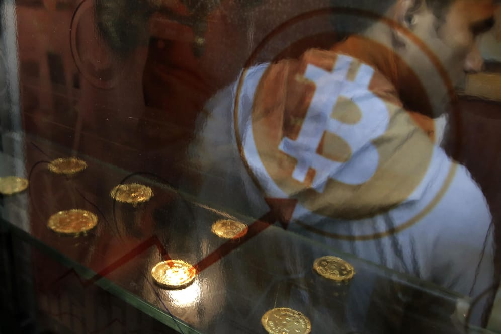 Ein Mann benutzt einen Bitcoin-Automaten. Die Digitalwährung wird nicht von zentralen Instanzen wie Notenbanken oder Regierungen kontrolliert und gewährt bei Überweisungen Anonymität.