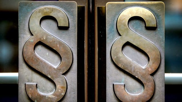 Paragrafen-Symbole an den Türgriffen zum Eingang eines Gerichts.