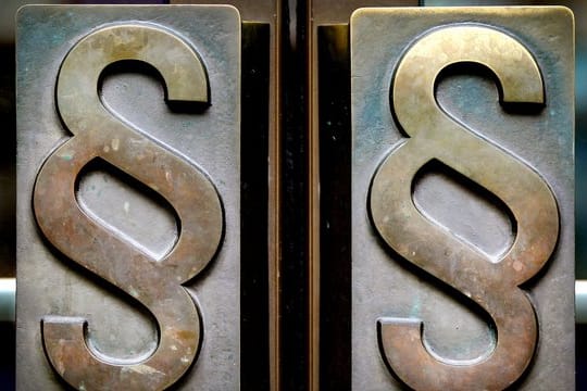 Paragrafen-Symbole an den Türgriffen zum Eingang eines Gerichts.