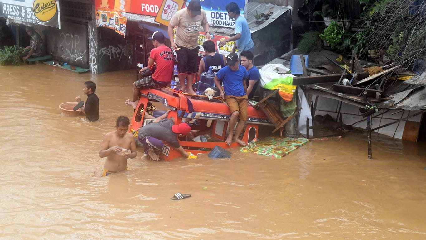 Menschen sitzen auf einem überfluteten Bus in der Stadt Cagayan de Oro: Die Philippinen werden immer wieder von Stürmen verwüstet.
