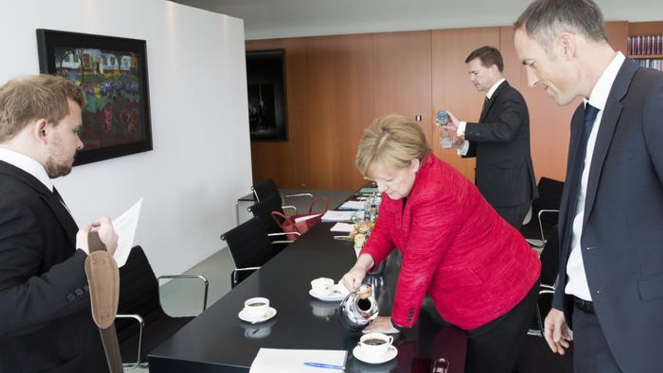 Angela Merkel schenkt ihren Interviewpartnern von t-online.de, Florian Harms (r.) und Patrick Diekmann (l.), Kaffee ein.