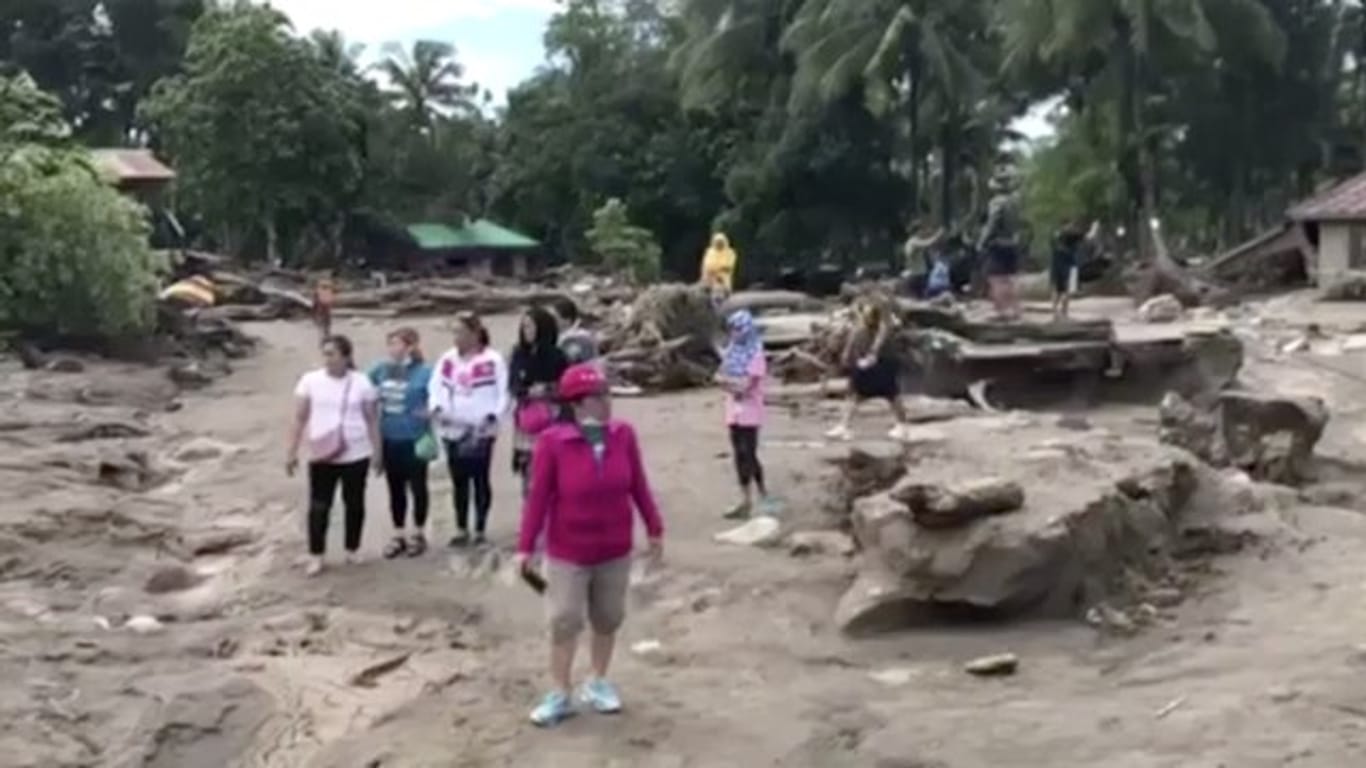 Ein Videostandbild zeigt Menschen, die am in einem von Tropensturm "Tembin" überschwemmten und zerstörten Gebiet in Lanao Del Norte (Philippinen) stehen.