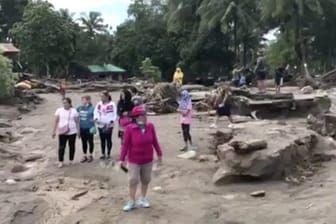 Ein Videostandbild zeigt Menschen, die am in einem von Tropensturm "Tembin" überschwemmten und zerstörten Gebiet in Lanao Del Norte (Philippinen) stehen.
