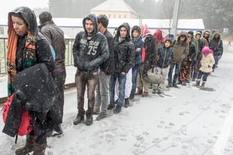 Flüchtlinge warten an der deutsch-österreichischen Grenze während eines Schneeschauers auf ihre Einreise nach Deutschland.