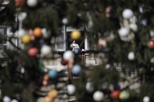 Papst Franziskus winkt während des Mittagsgebets in Vatikanstadt aus einem Fenster den Gläubigen zu.