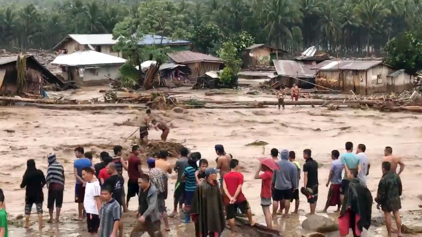 Dorfbewohner versuchen in Lanao Del Norte über ein reißendes Hochwasser zu gelangen.