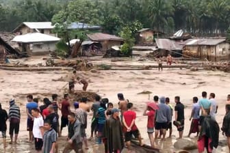Dorfbewohner versuchen in Lanao Del Norte über ein reißendes Hochwasser zu gelangen.