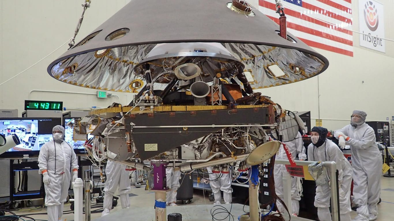 US-Raumfahrtspezialisten senken die Hülle eines "InSight"-Landefahrzeuges auf die Basis: 2018 geht es für die Nasa mit dem neuen Lander zum Mars.