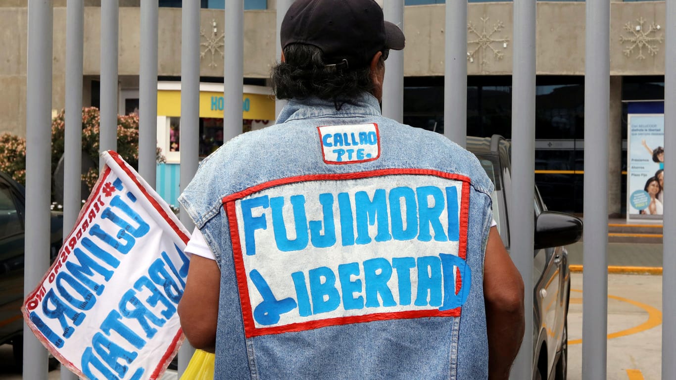 Ein Unterstützer trägt eine Weste mit der Aufschrift "Fujimori Libertad". Er beteiligt sich an einer Mahnwache für den ehemaligen Präsidenten Alberto Fujimori vor einer peruanischen Klinik. Dort wird Fujimori wegen einer Herzerkrankung behandelt.