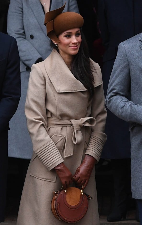 Meghan Markle kombinierte eine Luxustasche zu ihrem beigefarbenen Mantel.