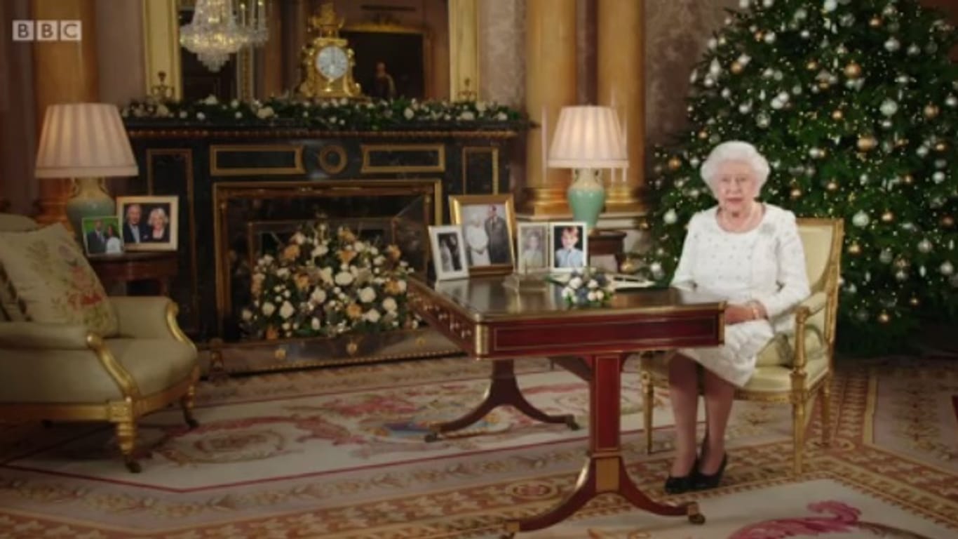 Auf dem Schreibtisch stehen jeweils ein Porträt von Prinzessin Charlotte und Prinz George und zwei Bilder von Königin Elizabeth II. und Gatte Prinz Philip. Auf dem Bestelltisch ist ein Foto von Prinz Charles und seiner Camilla sowie eins von Prinz Harry und seiner Verlobten Meghan Markle zu sehen.