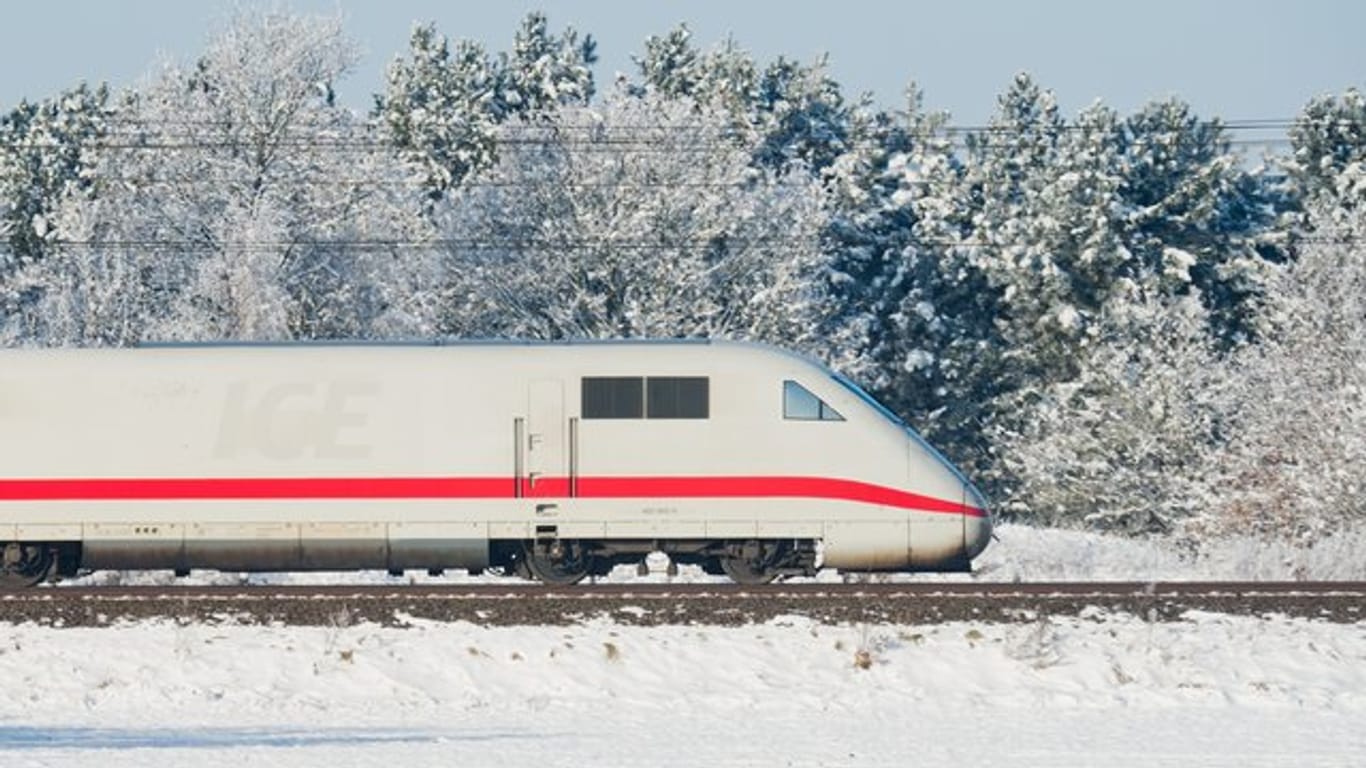 Ein ICE der Deutschen Bahn fährt durch eine weiße Winterlandschaft.