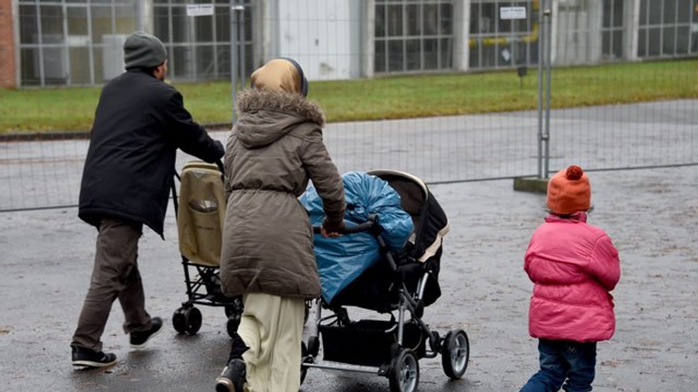 Eine Flüchtlingsfamilie geht in Boostedt über das Gelände einer Erstaufnahmeeinrichtung.