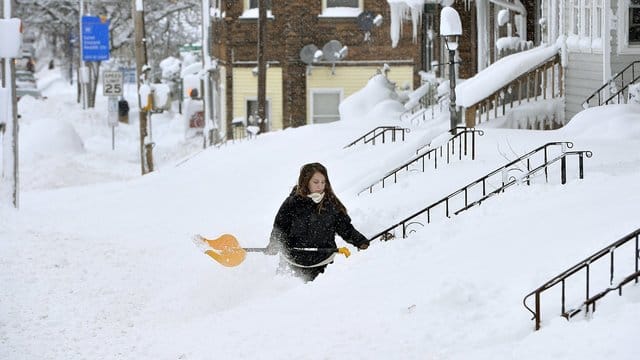 Eine Frau kämpft sich durch die Schneeberge.