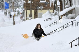 Eine Frau kämpft sich durch die Schneeberge.