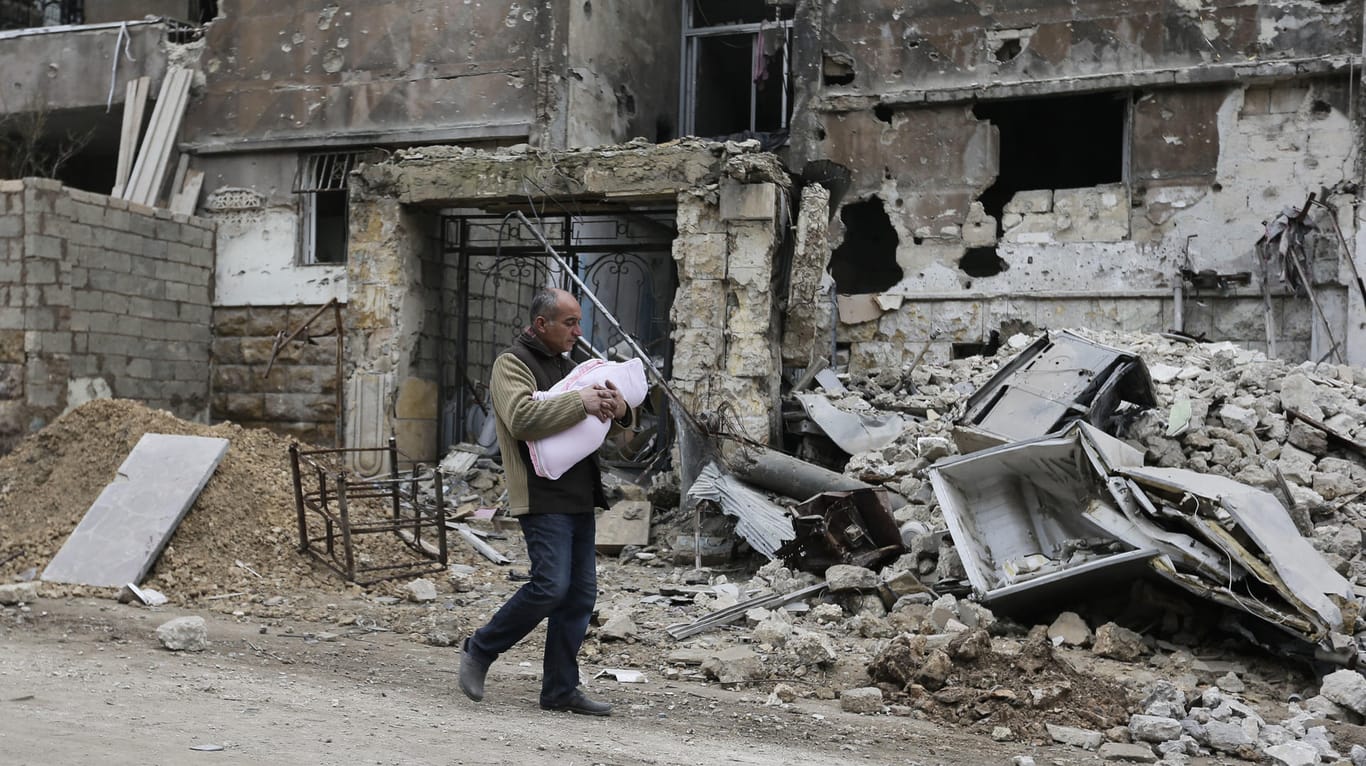 Ein im Januar 2017 aufgenommenes Foto zeigt einen Mann mit einem Kleinkind im östlichen Stadtteil Salaheddine in der vom Krieg zerstörten Stadt Aleppo.