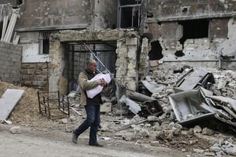 Ein im Januar 2017 aufgenommenes Foto zeigt einen Mann mit einem Kleinkind im östlichen Stadtteil Salaheddine in der vom Krieg zerstörten Stadt Aleppo.