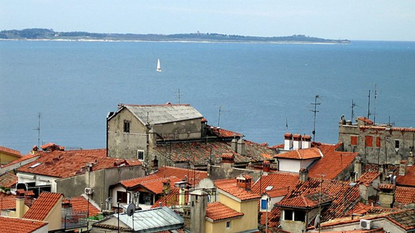 Blick auf die Bucht vom slowenischen Piran aus, dessen Häuser im Vordergrund zu sehen sind.