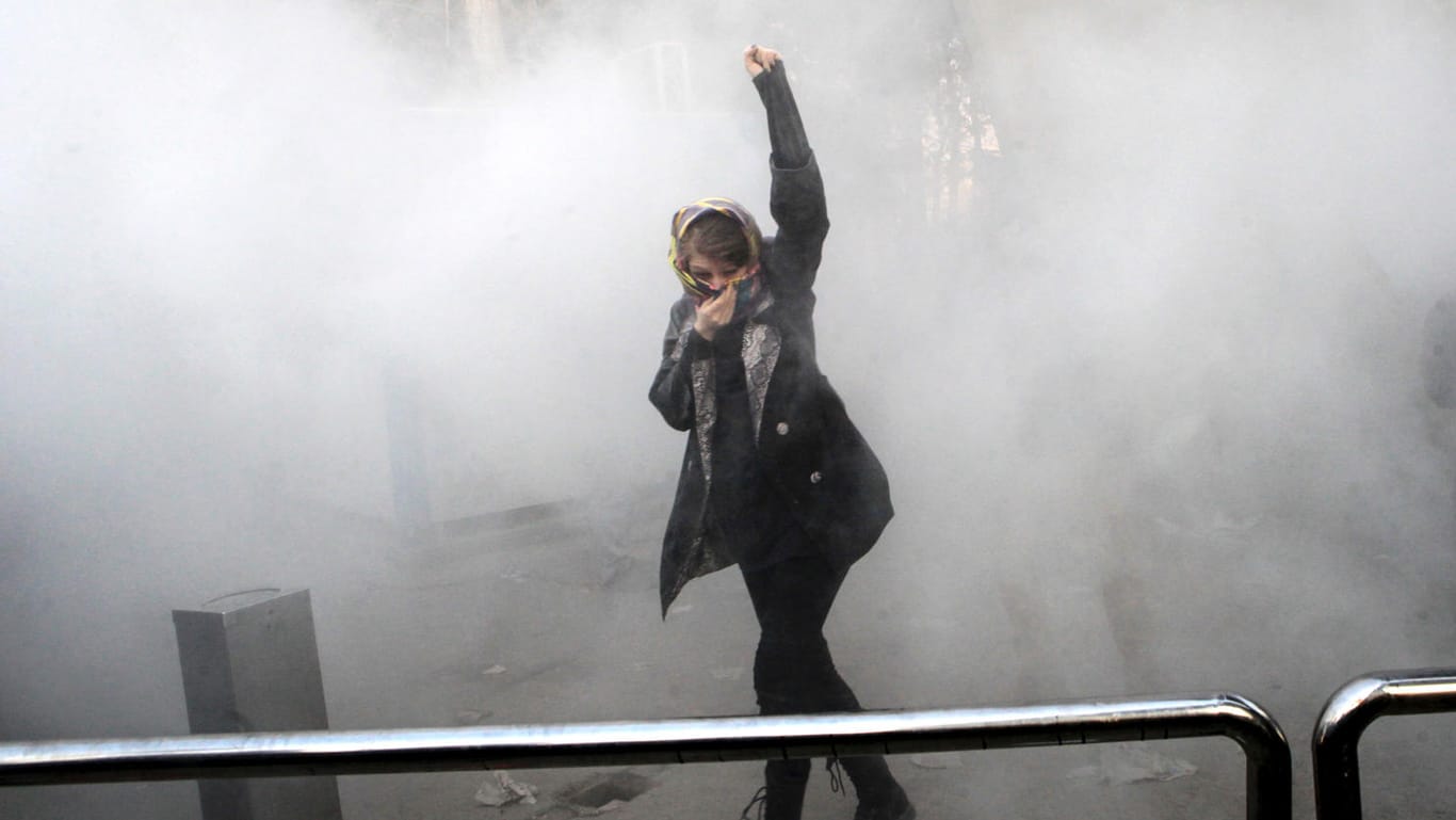 Eine Demonstrantin hebt inmitten von Tränengasschwaden vor der Universität in Teheran die Faust: Am dritten Tag der Demonstrationen griffen die Proteste auf die Hauptstadt Teheran über.