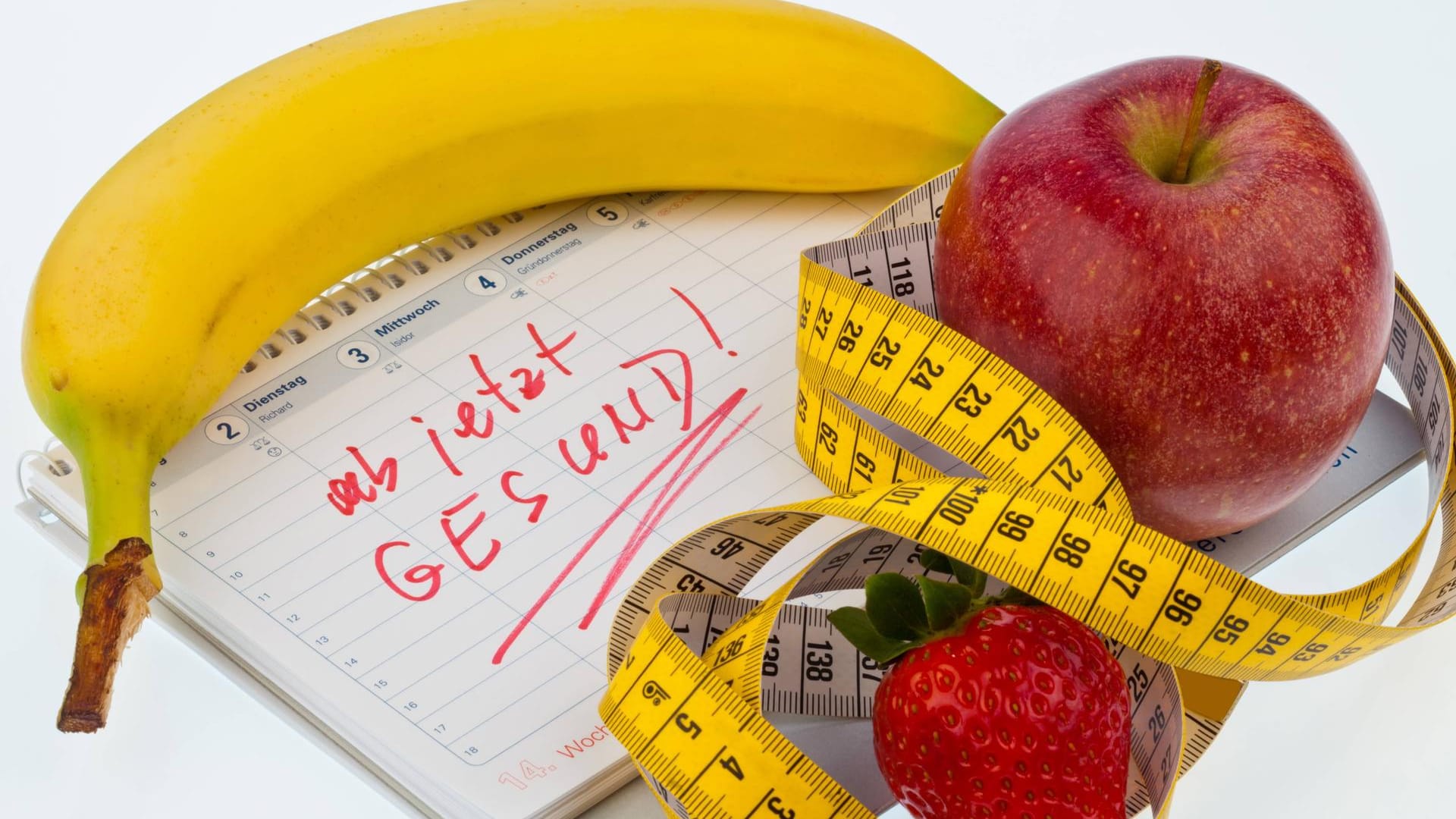 Apfel, Massband und Kalender: Ein guter Mix für den Vorsatz, sich gesünder zu ernähren.