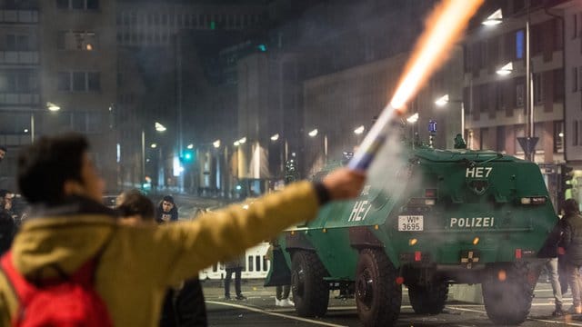Ein Mann brennt in unmittelbarer Nähe eines gepanzerten Polizeifahrzeugs in Frankfurt am Main Feuerwerk ab. Ein Mann brennt in unmittelbarer Nähe eines gepanzerten Polizeifahrzeugs in Frankfurt am Main Feuerwerk ab.
