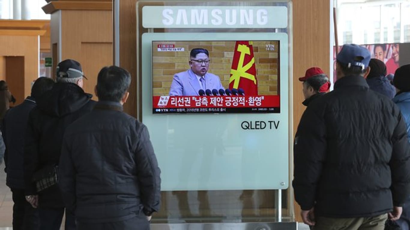 Reisende sehen sich im Hauptbahnhof von Seoul (Südkorea) auf einem Fernseher die Neujahrsansprache des nordkoreanischen Machthabers Kim Jong Un an.