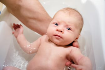 Ein Baby wird gebadet: Der wichtigste Grund für heißes Wasser bei der Geburt war früher die Vernichtung von schädlichen Keimen.