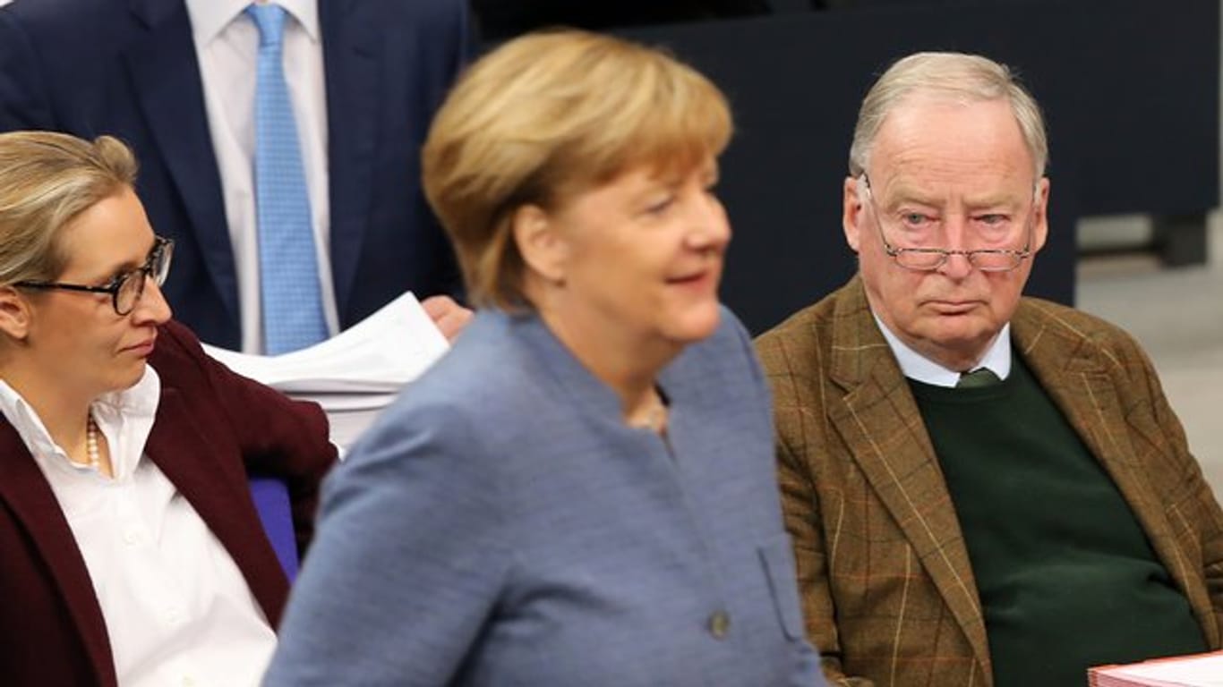 Bundeskanzlerin Angela Merkel geht während der Sitzung im Deutschen Bundestag in Berlin an der Fraktion der AfD mit den Vorsitzenden Alice Weidel und Alexander Gauland vorbei.
