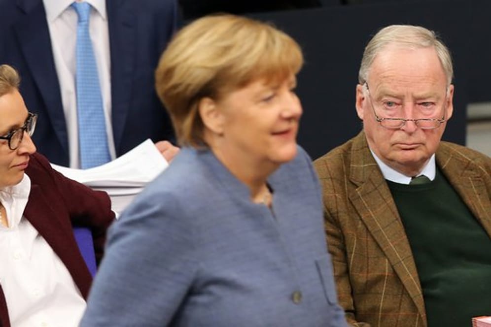 Bundeskanzlerin Angela Merkel geht während der Sitzung im Deutschen Bundestag in Berlin an der Fraktion der AfD mit den Vorsitzenden Alice Weidel und Alexander Gauland vorbei.