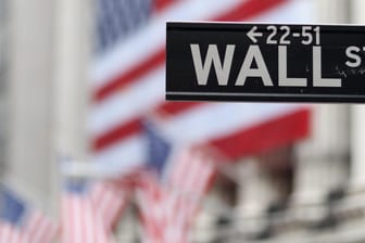 Blick auf die Börse in New York hinter einem Wall Street-Schild: Der Dow Jones ist dank weltweit guter Konjukturdaten im Aufwind.