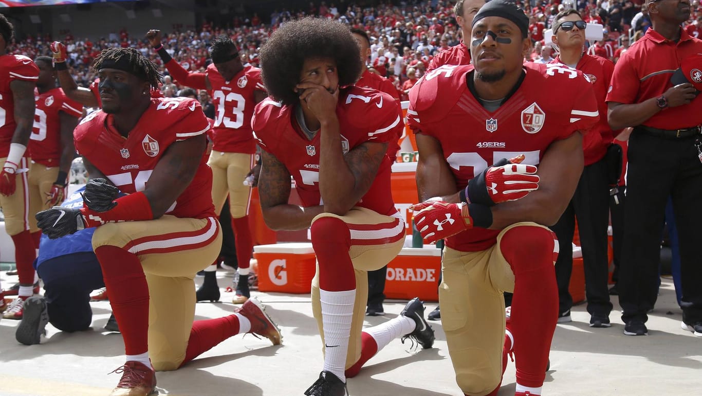 Quarterback Colin Kaepernick (m., hier noch im Trikot der San Francisco 49ers) gilt als Urheber der Proteste.