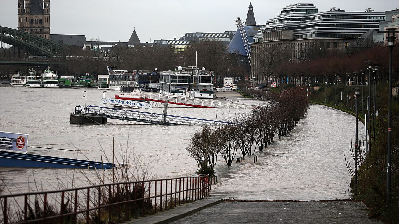 Ein überfluteter Uferweg am Rhein in Köln: Der Wasserstand steigt dort zurzeit um zwei bis drei Zentimeter pro Stunde.
