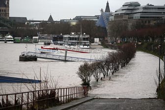 Ein überfluteter Uferweg am Rhein in Köln: Der Wasserstand steigt dort zurzeit um zwei bis drei Zentimeter pro Stunde.