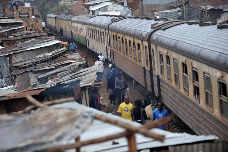Passagierzug durch den Slum: In Nairobi fährt die Uganda-Bahn an den Wellblechhütten der Bewohner vorbei.