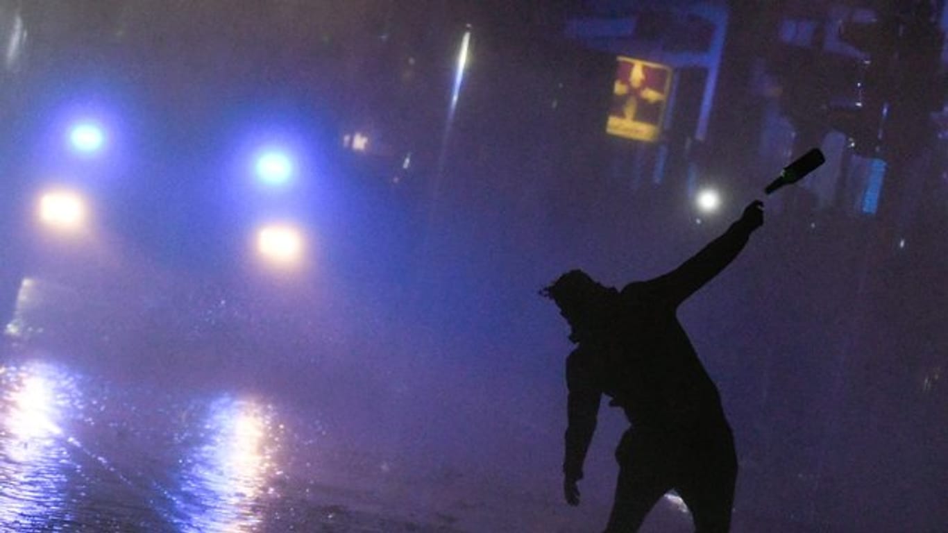 Ein Demonstrant attackiert bei den G20-Krawallen in Hamburg einen Wasserwerfer mit einem Flaschenwurf.