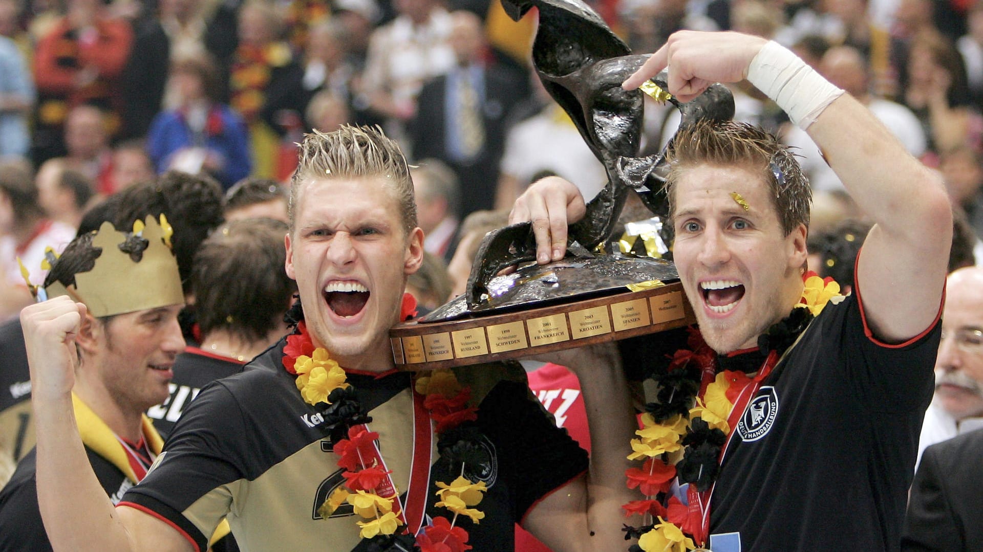 Lars Kaufmann 2007: Nach dem Titelgewinn bei der Heim-WM jubelt er mit Oliver Roggisch (r.) und der Trophäe.