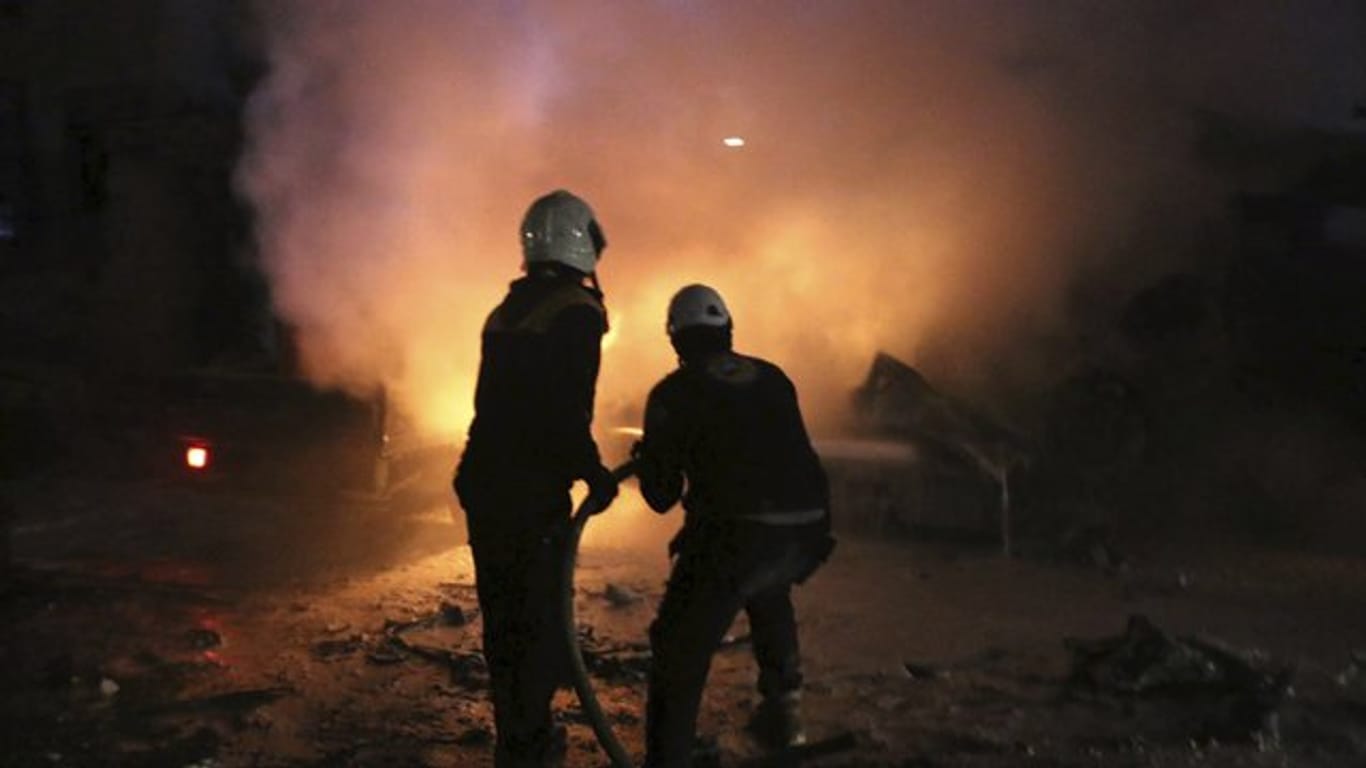 Mitarbeiter der sogenannten "Weißhelme" in Idlib beim Löschen eines Feuers nach einer Explosion.