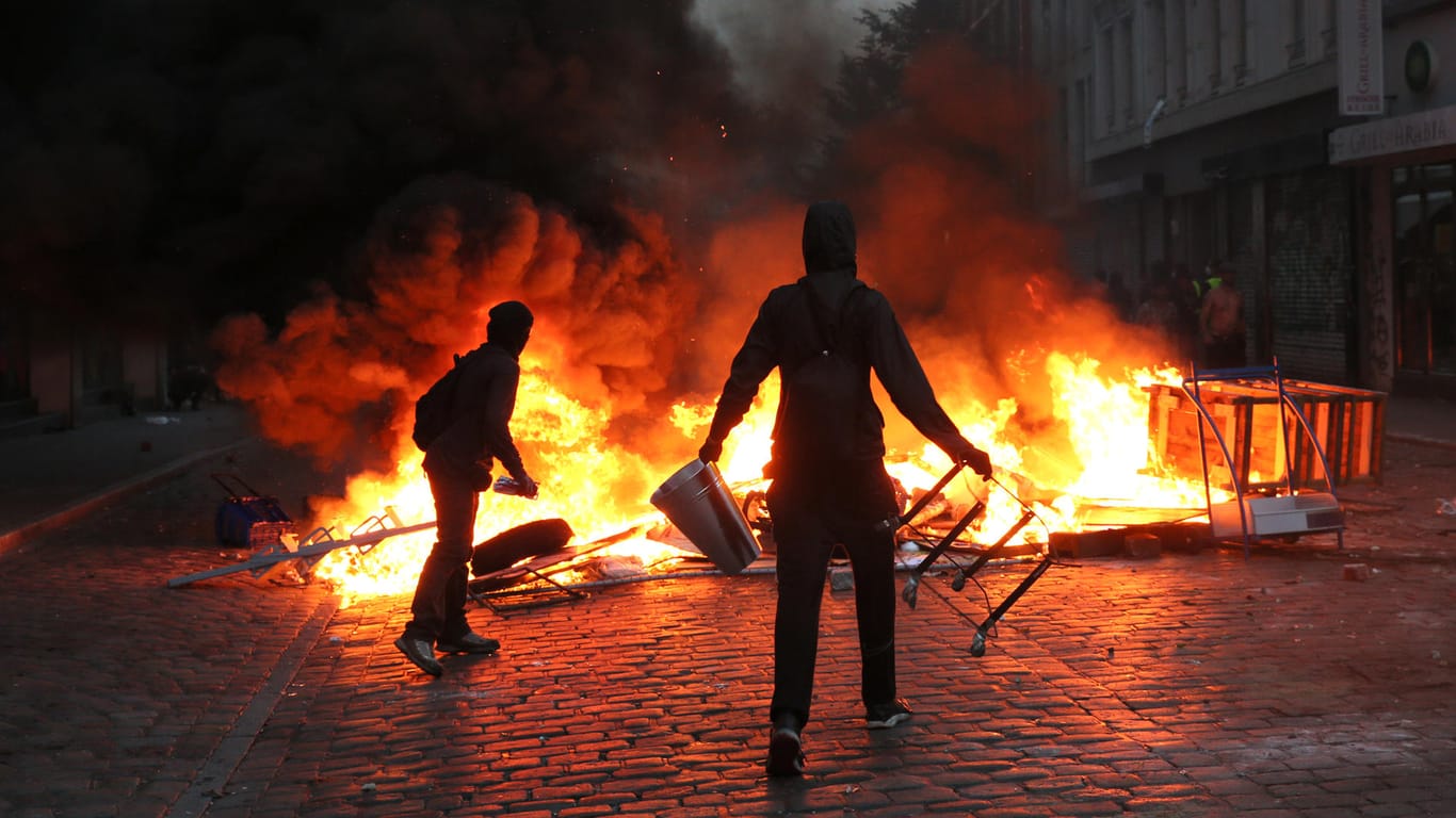 Randalierer im Schanzenviertel in Hamburg vor einer brennenden Barrikade: An solchen Ausschreitungen soll sich ein Polizist aus München aktiv beteiligt haben.