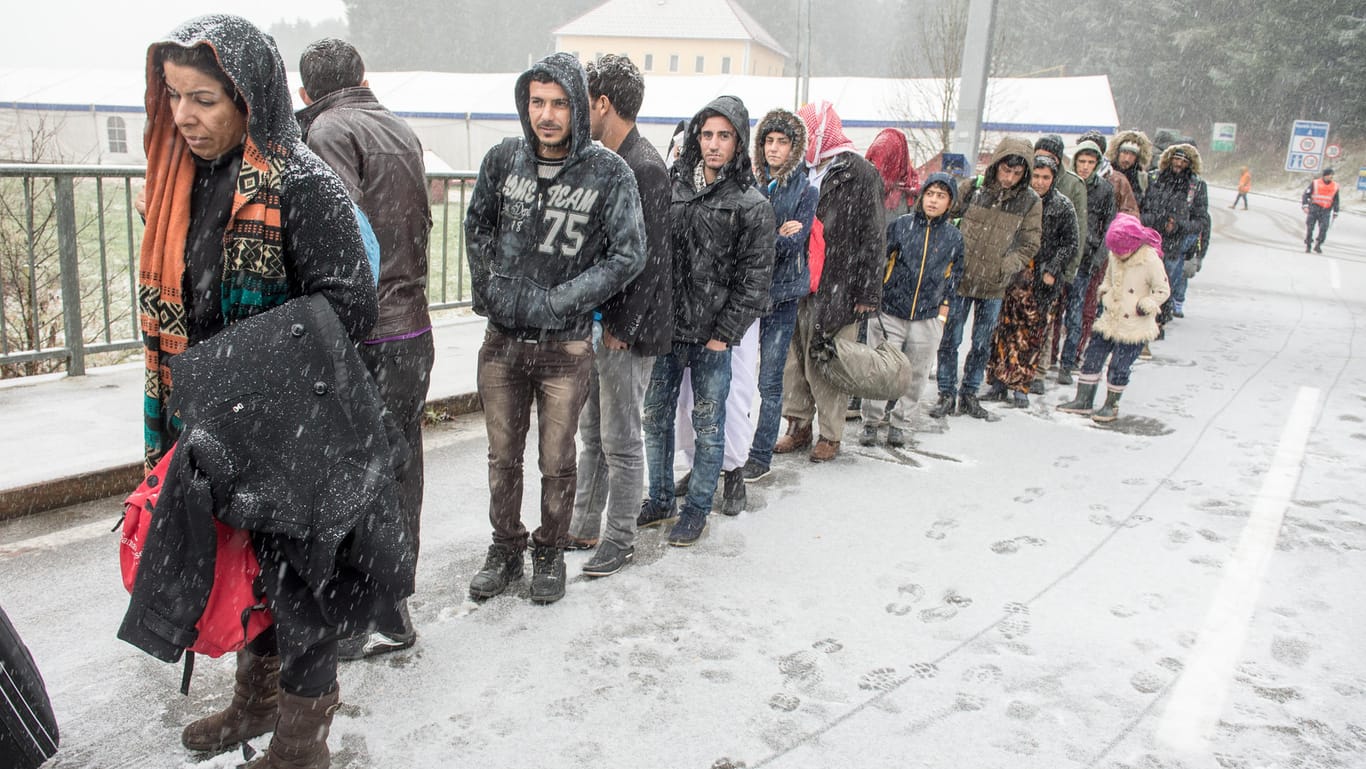Flüchtlinge warten an der deutsch-österreichischen Grenze nahe Wegscheid (Bayern) während eines Schneeschauers auf ihre Einreise nach Deutschland.
